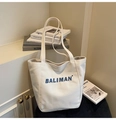 Detail of blue BALIMAN 3D letter embroidery on a minimalist white canvas tote bag - Off White