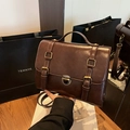 Vintage brown leather satchel with brass buckle and adjustable strap in a lifestyle setting - Brown
