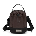 Detail van multifunctionele crossbody emmertas met trekkoordsluiting en modieus leren label - Bruin
