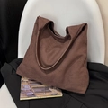 Large dark brown matte suede tote bag for women showing spacious commuter style on a chair - Coffee