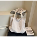 Textura detallada del bolso tote de pana blanca con parche de logo en cuero y asas largas - Blanco Roto