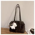 Detail der dunkelbraunen Wildleder-Schultertasche mit Metallösen und weißem Plüsch-Hundeanhänger - Mit Anhänger / Dunkelbraun