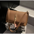 Detail of brown lychee texture leather bag with elegant gold hardware on stone background - Coffee