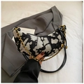 Detail of black and white woven crescent bag with gold chain and leather strap - Black