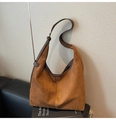 Detail einer braunen Wildleder-Hobo-Tasche mit verstellbarem Lederriemen auf Dekoration - Braun