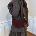 Borsa a mezzaluna in camoscio testa di moro con frange in pelle e pompon su modella - Rosso Vino Con Pendente