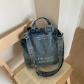 Retro blue washed denim tote bag featuring white artistic lettering and broad shoulder strap - Light Blue