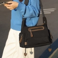 Bolso mensajero negro con detalles de cuero marrón y colgantes de corazón en jersey - Negro