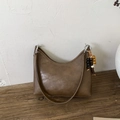 Borsa hobo minimalista in pelle marrone con ciondolo etnico su panca di legno - Marrone (Con Pendaglio)