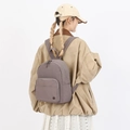 Dark brown nylon vintage backpack for women shown on model in urban casual style - Purple