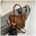 Detailed view of dark brown woven bucket bag with leather puppy charm and chain accent - Woven Design / Brown (With Puppy Charm)