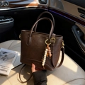 Retro dark brown leather bucket bag with tassel charm and adjustable shoulder strap - Coffee