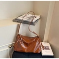 Vista detallada del bolso tote de cuero marrón brillante con textura suave y cremallera - Marrón