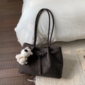 Macro detail of dark brown vintage leather tote bag with stylish buckle and plush puppy charm - With Pendant / Brown
