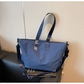 Detalle del bolso tote azul oscuro con textura de nylon impermeable y bolsillo lateral - Azul