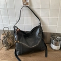 Minimalist black faux leather tote bag with stylish side tassels and metallic logo detail - Black