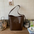Retro dark brown bucket bag with vintage leather texture and wide shoulder strap style - Brown