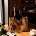 Grand sac cabas vintage en cuir marron pour femme avec pendentif pompon sur table en bois - Avec Pendentif / Marron