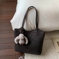 Detail of vintage matte leather tote with white contrast stitching and bunny charm - Ebony With Pendant