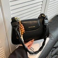 Elegante schwarze Schultertasche aus Kunstleder mit Flechtriemen und bunten Holzperlen - Schwarz