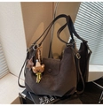 Détail du sac à main en daim marron foncé avec lettrage doré et pendentif ourson - Café avec Pendentif