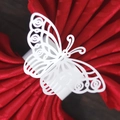 Macro detail of laser-cut white butterfly napkin ring on elegant red satin cloth - White