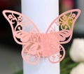 Gros plan détaillé d'un rond de serviette papillon rose découpé au laser avec motifs floraux - Rose