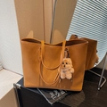 Borsa tote marrone capiente con ciondolo di peluche e perle su mobile scuro - Con Ciondolo / Marrone