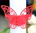 Macro shot of laser-cut red butterfly napkin ring with intricate hollow floral patterns - Pearlescent Red