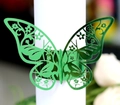 Macro shot of butterfly napkin ring with emerald green laser-cut floral patterns - Reflective Green