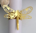 Detail eines goldenen Libellen-Serviettenrings mit Laserschnitt-Hohlmuster für Hochzeiten - Reflektierendes Gold