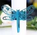 Detailaufname des lasergeschnittenen Libellen-Serviettenrings mit Herzmuster in Blau - Reflektierendes Blau