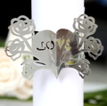 Macro shot of silver heart-shaped napkin ring with rose design and LOVE laser cutout - Reflective Silver