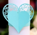 Detail of laser-cut heart paper napkin ring with cyan hollow scroll patterns for weddings - Light Blue
