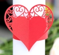 Close-up of red heart laser-cut paper napkin ring with elegant floral filigree pattern - Pearlescent Red