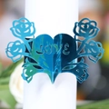 Nahaufnahme von metallisch blauem Serviettenring aus Papier mit Herz- und Rosendesign - Reflektierendes Blau