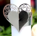 Macro shot of silver heart-shaped napkin ring with detailed laser-cut hollow patterns - Reflective Silver