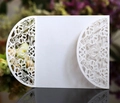 Detail of white laser-cut floral wedding invitation cover with intricate hollow pattern - White