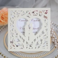 Detalle de invitación de boda cortada con láser con elegante corazón y siluetas en crema - Blanco Leche