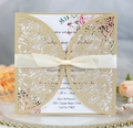Detailed macro of laser-cut gold wedding invitation with rose pattern and satin bow - Beige Gold