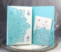 Macro shot of light blue laser cut wedding invitation with floral printed inner card - Tiffany Blue