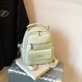 Chic light green pebbled leather backpack with silver logo on a silver suitcase - Beige