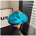Detail view of bright blue acrylic evening clutch with wavy texture and gold metal chain - Blue