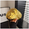 Detailaufnahme einer goldfarbenen Abendtasche in Kieselform mit eleganter Metallkette - Gold