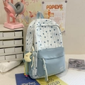 Detail eines Rucksacks mit Sternmuster und einem süßen gelben Mond Plüschanhänger - Blau mit Anhänger