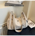 Détail du sac bandoulière en nylon crème avec poches zippées et large sangle tissée - Blanc Cassé