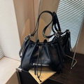 Schwarze gesteppte Eimertasche aus Kunstleder mit Kordelzug und silbernen Beschlägen - Schwarz