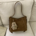 Détail du sac seau vintage marron foncé avec coutures contrastées et charm de chien peluche - Marron avec Pendentif