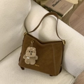 Dettaglio della borsa a spalla marrone vintage con cuciture bianche e ciondolo a orsetto - Marrone con ciondolo