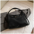 Schwarze Retro-Hobo-Tasche in Matt mit goldener Metallschnalle auf minimalistischem Bett - Schwarz ohne Anhänger